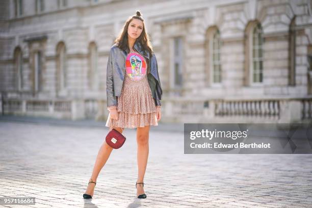 Landiana Cerciu wears a leather jacket, a ruffled pink dress with lace, a red bag during London Fashion Week February 2018 on February 16, 2018 in...