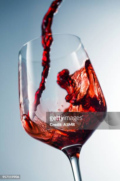 red wine pouring in glass - transbordar imagens e fotografias de stock
