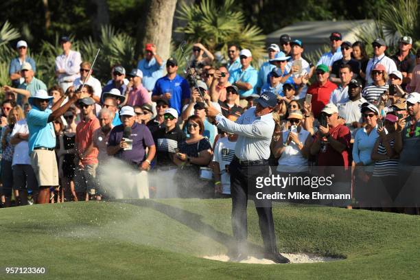 Phil Mickelson of the United States plays a shot from a bunker on the 14th hole during the first round of THE PLAYERS Championship on the Stadium...