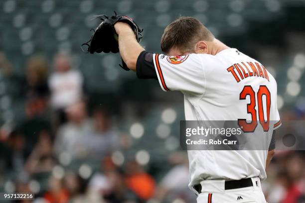 Starting pitcher Chris Tillman of the Baltimore Orioles reacts after giving up a grand slam to the Kansas City Royals in the first inning at Oriole...