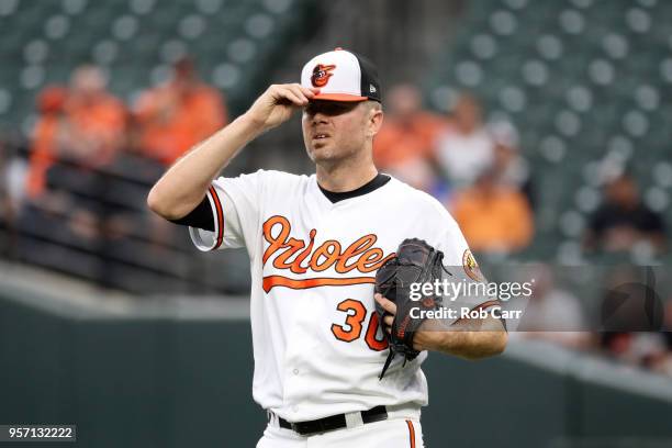 Starting pitcher Chris Tillman of the Baltimore Orioles reacts after giving up a grand slam to the Kansas City Royals in the first inning at Oriole...