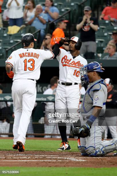 Catcher Salvador Perez of the Kansas City Royals looks on as Manny Machado of the Baltimore Orioles celebrates with Adam Jones after hitting a two...