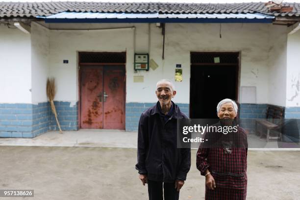 This photo taken on April 24, 2018 shows Yang Heping standing with his wife in front of their house built after the 2008 Sichuan earthquake in...