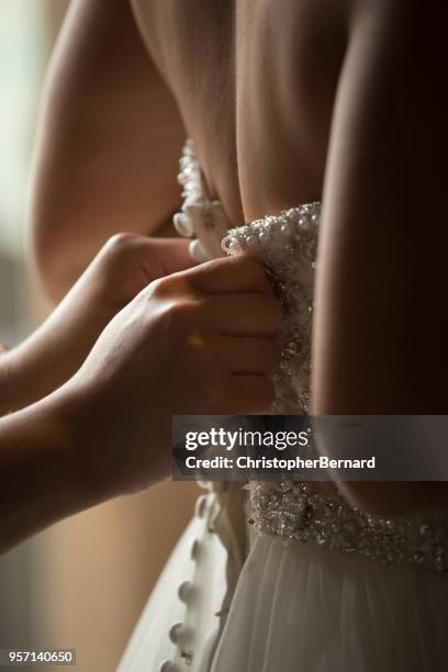 asian bride help getting dressed - bride and groom back stock pictures, royalty-free photos & images