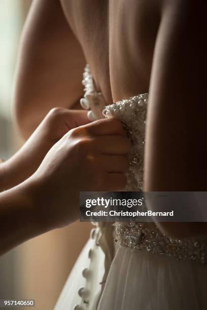 asian bride help getting dressed - prepare stock pictures, royalty-free photos & images