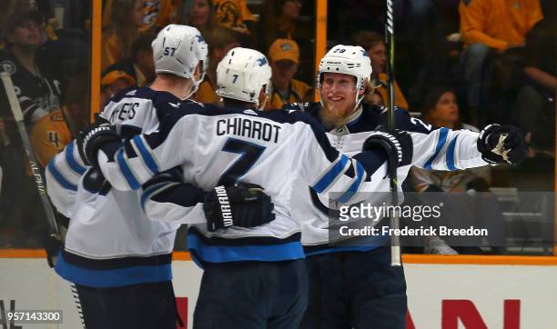 Tyler Myers , Ben Chiarot, and Patrik Laine of the Winnipeg Jets celebrate after a goal against the Nashville Predators during the first period in...