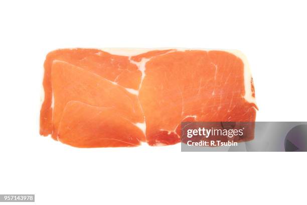 closeup on a piece of spanish serrano ham, isolated on white - jamon serrano photos et images de collection