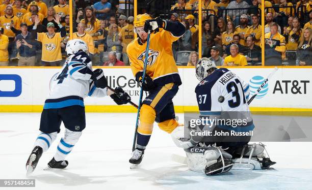 Connor Hellebuyck of the Winnipeg Jets makes the save against Ryan Johansen of the Nashville Predators as Josh Morrissey defends in Game Seven of the...