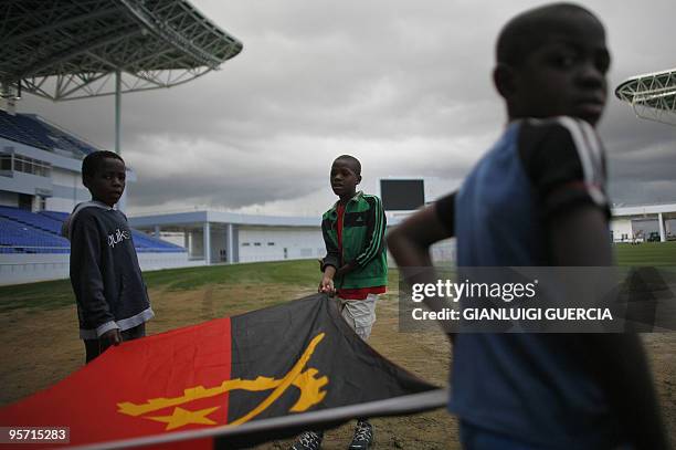Angolan kids hold an Angolan flag as they rehearse at the Tundavala Stadium on January 11, 2010 in Lubango. Lubango is one of the four city hosting...