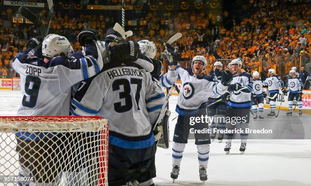 Andrew Copp and Connor Hellebuyck of the Winnipeg Jets celebrate with their teammates after a 5-1 Jets Victory in Game Seven of the Western...