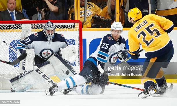 Connor Hellebuyck of the Winnipeg Jets eyes the shot of Alexei Emelin of the Nashville Predators as Paul Stastny defends in Game Seven of the Western...