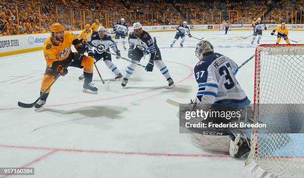 Craig Smith of the Nashville Predators takes a shot on goalie Connor Hellebuyck of the Winnipeg Jets during the third period of a 5-1 Jets victory in...