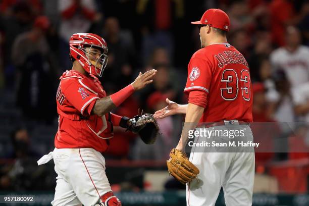 Martin Maldonado congratulates Jim Johnson of the Los Angeles Angels of Anaheim after defeating the Minnesota Twins 7-4 in a game at Angel Stadium on...