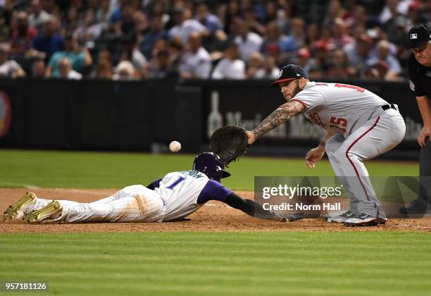 Jarrod Dyson of the of the Arizona Diamondbacks safely dives back to first base as Matt Adams of the Washington Nationals waits for the throw from...