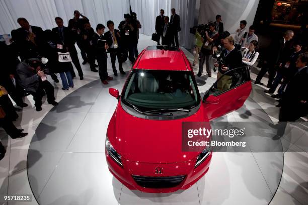 Members of the media look at the Honda Motor Co. CR-Z hybrid after its unveiling on day one of the 2010 North American International Auto Show in...