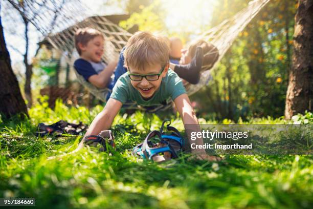 kids playing on hammock in the back yard - boy lying down stock pictures, royalty-free photos & images