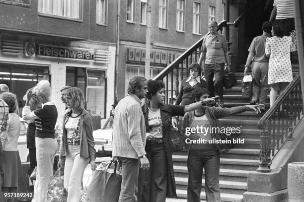 Passanten in der Schönhauser Allee im Berliner Stadtbezirk Prenzlauer Berg, aufgenommen am . Ein Mann lässt sich von zwei Frauen den Weg erklären.