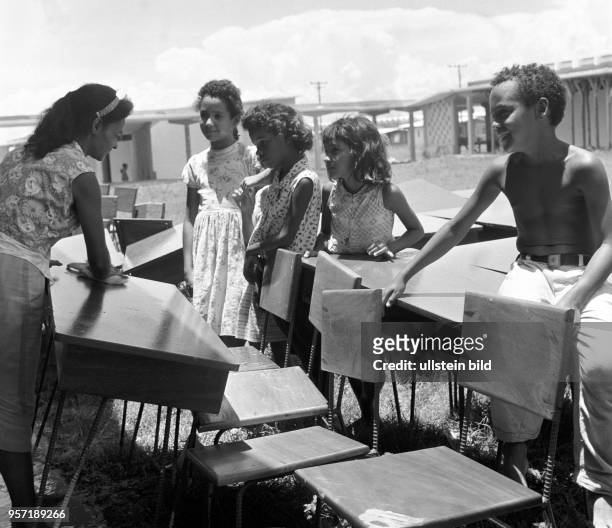 Kubanische Kinder mit neuen Schulmöbeln kurz vor der Einweihung einer neugebauten Schule in Havanna , aufgenommen 1962