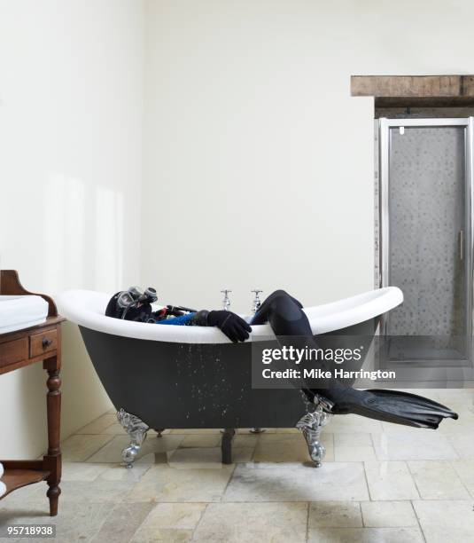 scuba diver in laying in a bath - baignoire sur pieds photos et images de collection