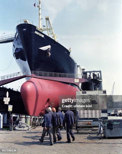 Schiffbauer befinden sich im Trockendock der Warnemünder Warnowwerft auf dem Weg zum im Bau befindlichen Frachtschiff "Ulan Bator", aufgenommen 1985....