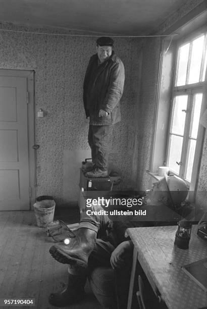 Ein Bergmann wärmt sich auf einem Ofen stehend seine Füße, die durch den Einsatz im Schlüsselstollen, dem zentralen Entwässerungsstollen der...