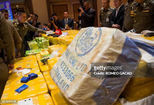 Royal Thai national police chief general Chaktip Chaijinda inspects seized drugs and guns during a press conference in Bangkok on May 11, 2018. - Ten...