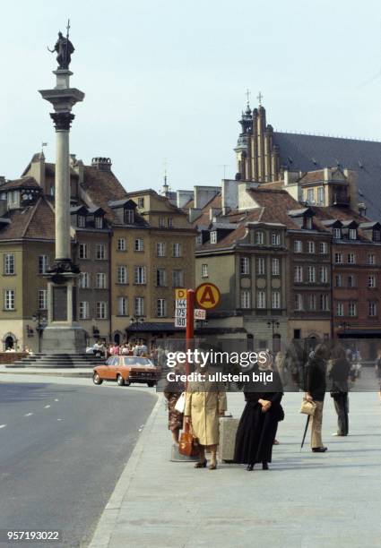 Passanten an einer Haltestelle auf dem Platz am Königsschloss in Warschau mit der Sigismund-Säule , aufgenommen im Juni 1985.