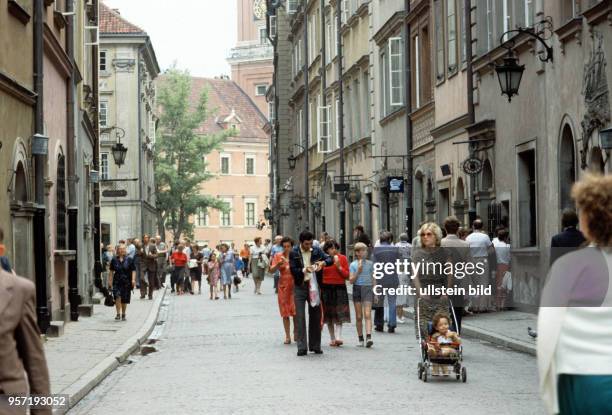 Passanten in einer von historischen Häusern gesäumten Fußgängerstraße in der Altstadt von Warschau, aufgenommen im Juni 1985.