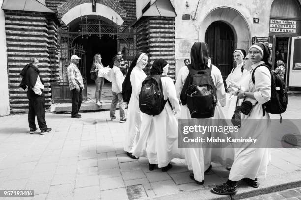 gruppe von nonnen in der nähe von armenische kathedrale von lemberg - soutane stock-fotos und bilder