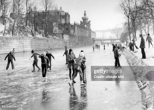 Eisläufer vergnügen sich im Winter 1981 auf dem zugefrorenen Zwingerteich in Dresden. Im Hintergrund ist der Dresdner Zwinger zu sehen.