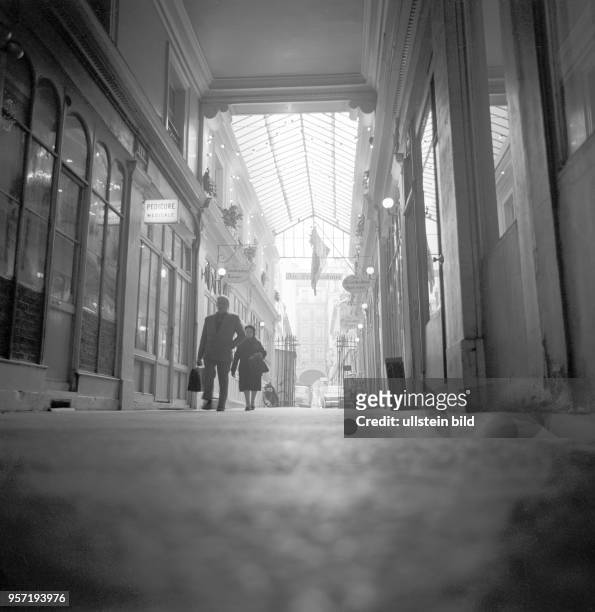 Blick durch den Gang einer Markthalle in Paris, aufgenommen im November 1970. Im Geschäft links wird Pediküre angeboten.
