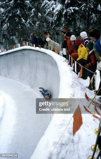 Zur VII. Kinder- und Jugendspartakiade im Februar 1979 bestreitet ein junger Rodler auf seinem Schlitten mit hoher Geschwindigkeit die Abfahrt auf...