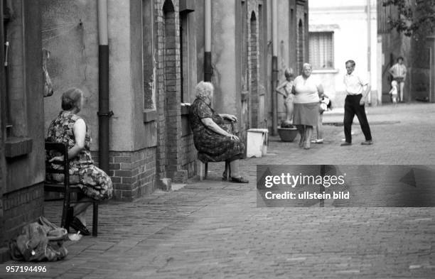 Ältere Hausfrauen haben Stühle auf die Straße gestellt und warten nun auf Abwechslung in der Wohnsiedlung der Kupferhütte Helbra, aufgenommen im...