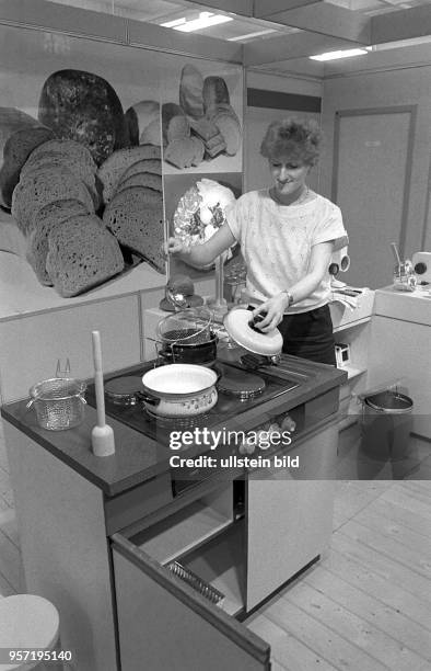 Eine Hostess demonstriert auf der Leipziger Messe einen Elektroherd und das dazu passende Geschirr aus DDR-Produktion, aufgenommen 1986. Konsumgüter...