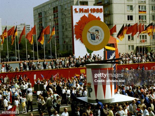 Junge Pioniere stellen auf der Demonstration am 1. Mai 1988 in der Karl_Marx_Allee in Berlin Wagen mit überdimensionaler Fanfare und Trommel und der...