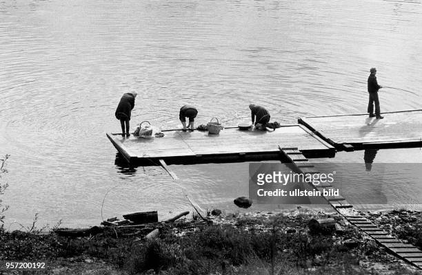Frauen aus der Stadt Wologda waschen im Wasser eines Flusses ihre Wäsche, ein Mann angelt, aufgenommen 1977. 500 km nordöstlich von Moskau gelegen...