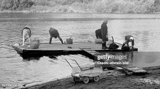 Frauen aus der Stadt Wologda waschen im Wasser eines Flusses ihre Wäsche, ein Mann angelt, aufgenommen 1977. 500 km nordöstlich von Moskau gelegen...