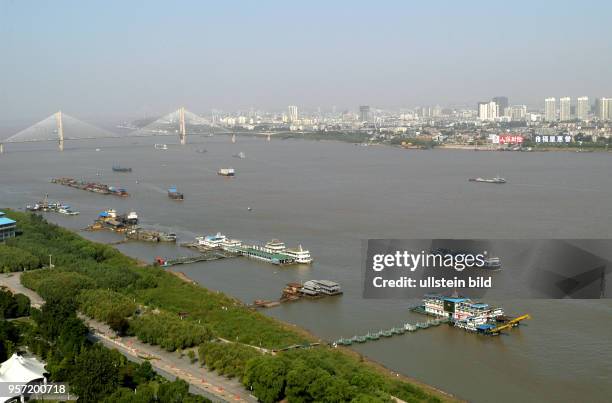 Blick über den Fluss Yangzi mit der Uferpromenade auf eine Silhouette von Hochhäusern in Wuhan, Hauptstadt der Provinz Hubei. Mit 5.200000 Einwohner...