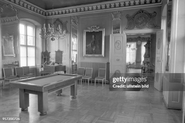 Ein Billardtisch, ein Flügel und Stühle stehen in der frühklassizistischen Umrahmung eines Saales in Schloss Rheinsberg in Rheinsberg, Foto vom . In...