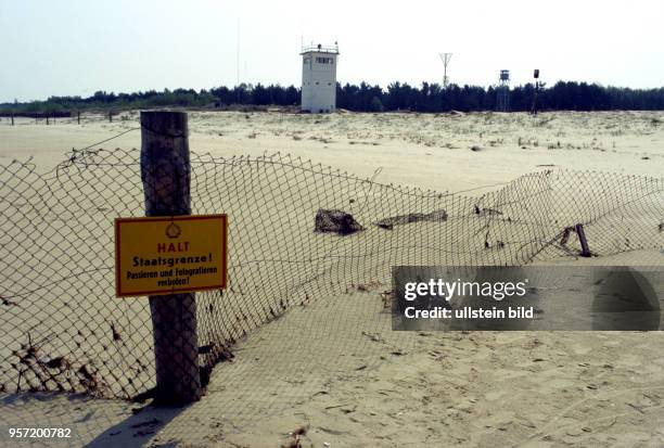 Ein einfacher Maschendrahtzaun mit Schildern "Halt Staatsgrenze" markiert den Grenzverlauf am Ostseestrand zwischen dem deutschen Ort Ahlbeck und dem...