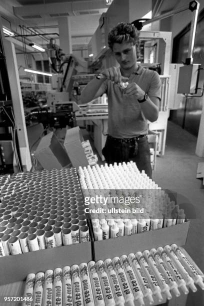 Ein junger Mann bereitet im VEB Elbe-Chemie in Dresden Zahnpastatuben für die Befüllung vor, aufgenommen im August 1990. Er ist froh, eine der...