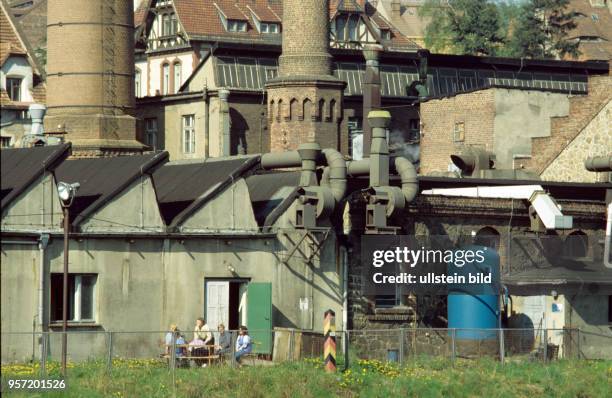 Alte Fabrikanlagen an der Uferstraße in Görlitz und eine Grenzmarkierungssäule auf dem DDR-Gebiet am Ufer der Lausitzer Neiße, Grenzfluß zu Polen,...