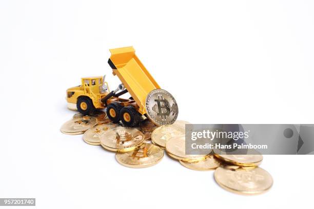 mining truck dumping a pile of bitcoin coins - mining truck stock-fotos und bilder