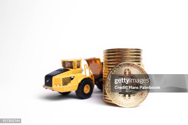mining truck next to a stack of bitcoins - mining truck stock-fotos und bilder