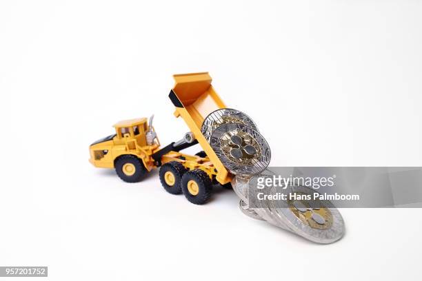 mining truck dumping a pile of ripple xrp coins - mining truck stock-fotos und bilder