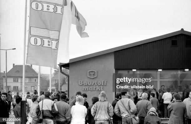 Bereits im Januar 1990 eröffnet OBI seinen ersten Baumarkt in Dresden - eine lange Menschenschlange wartet am Eröffnungstag auf den Einlaß.