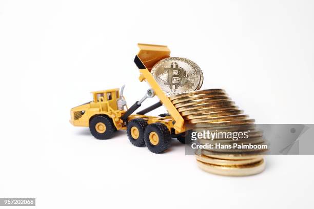 mining truck dumping a pile of bitcoin coins - mining truck stock-fotos und bilder