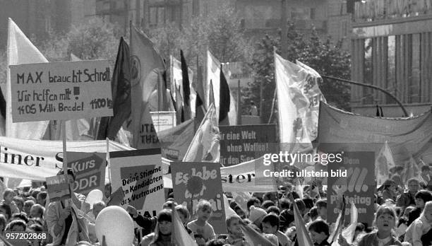 Demonstranten tragen Transparente mit der Aufschrift "Es lebe der 1. Mai", "Deine Stimme den Kandidaten des Vertrauens","Dem XII. Parteitag entgegen"...