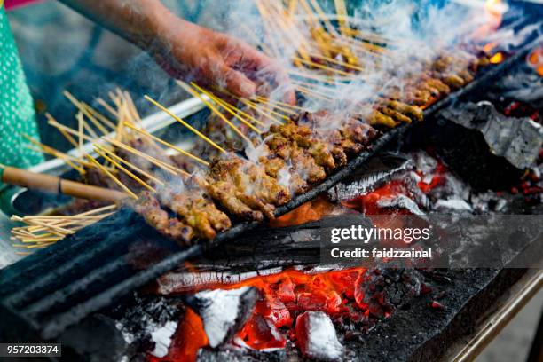 crepitantes satay de frango grelhado com chamas e fumaça - frango satay - fotografias e filmes do acervo