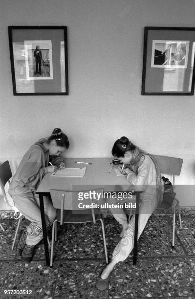 Zwei Schülerinnen der Palucca Schule Dresden sitzen an einem Tisch und lernen, über ihnen hängt ein Foto mit Gret Palucca, aufgenommen 1989. Die...